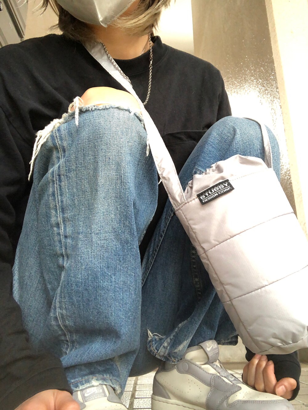 ブルー系のデニムパンツ、ブラック系のTシャツ/カットソー、グレー系のスニーカーを着用したレディースの春コーディネートの3枚目の写真