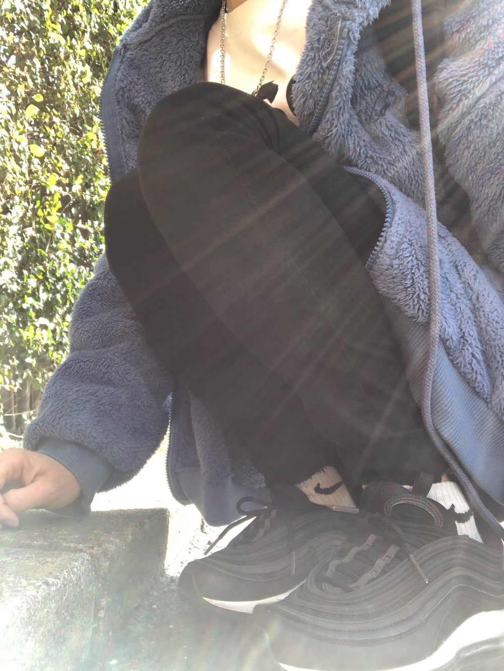 ブルー系のパーカー、ブラック系のデニムパンツ、ブラック系のスニーカーを着用したレディースの冬コーディネートの5枚目の写真