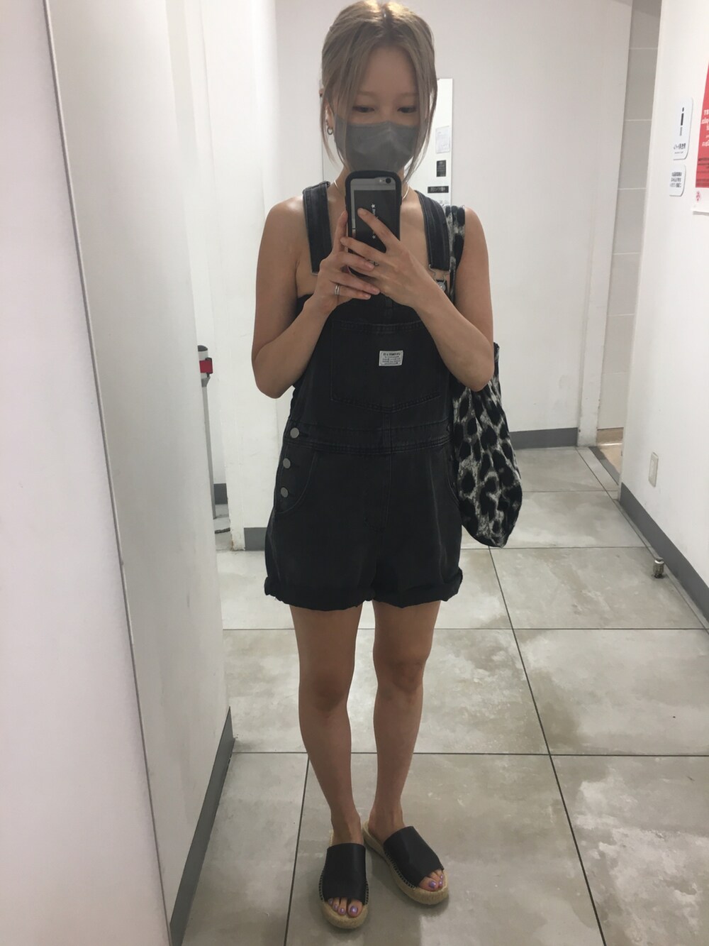 ブラック系のサロペット/オーバーオール、グレー系のトートバッグ、ブラック系のチューブトップを着用したレディースの秋コーディネートの3枚目の写真