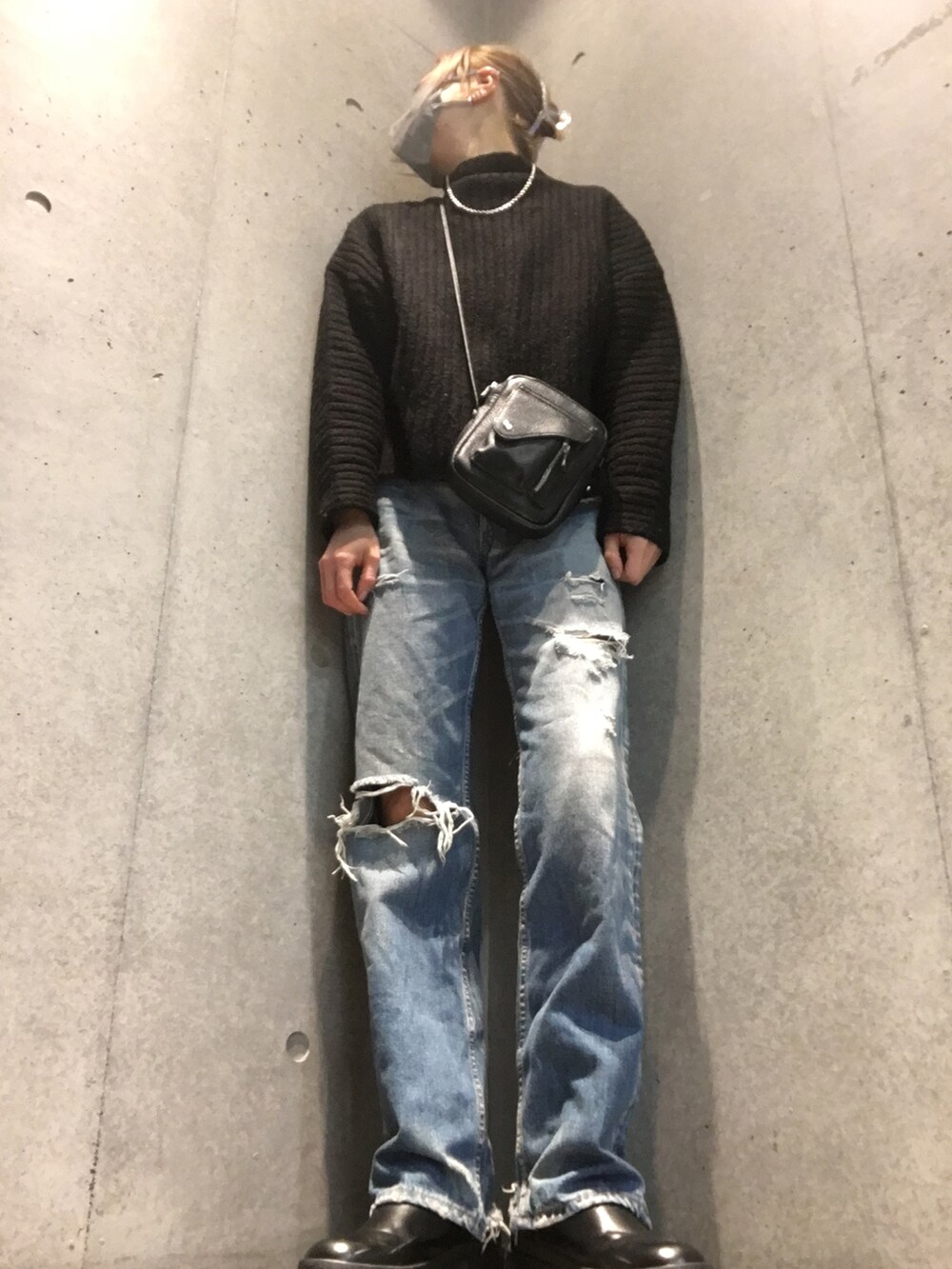 ブラック系のニット/セーター、ブラック系のショルダーバッグ、ホワイト系のブーツを着用したレディースの冬コーディネートの2枚目の写真