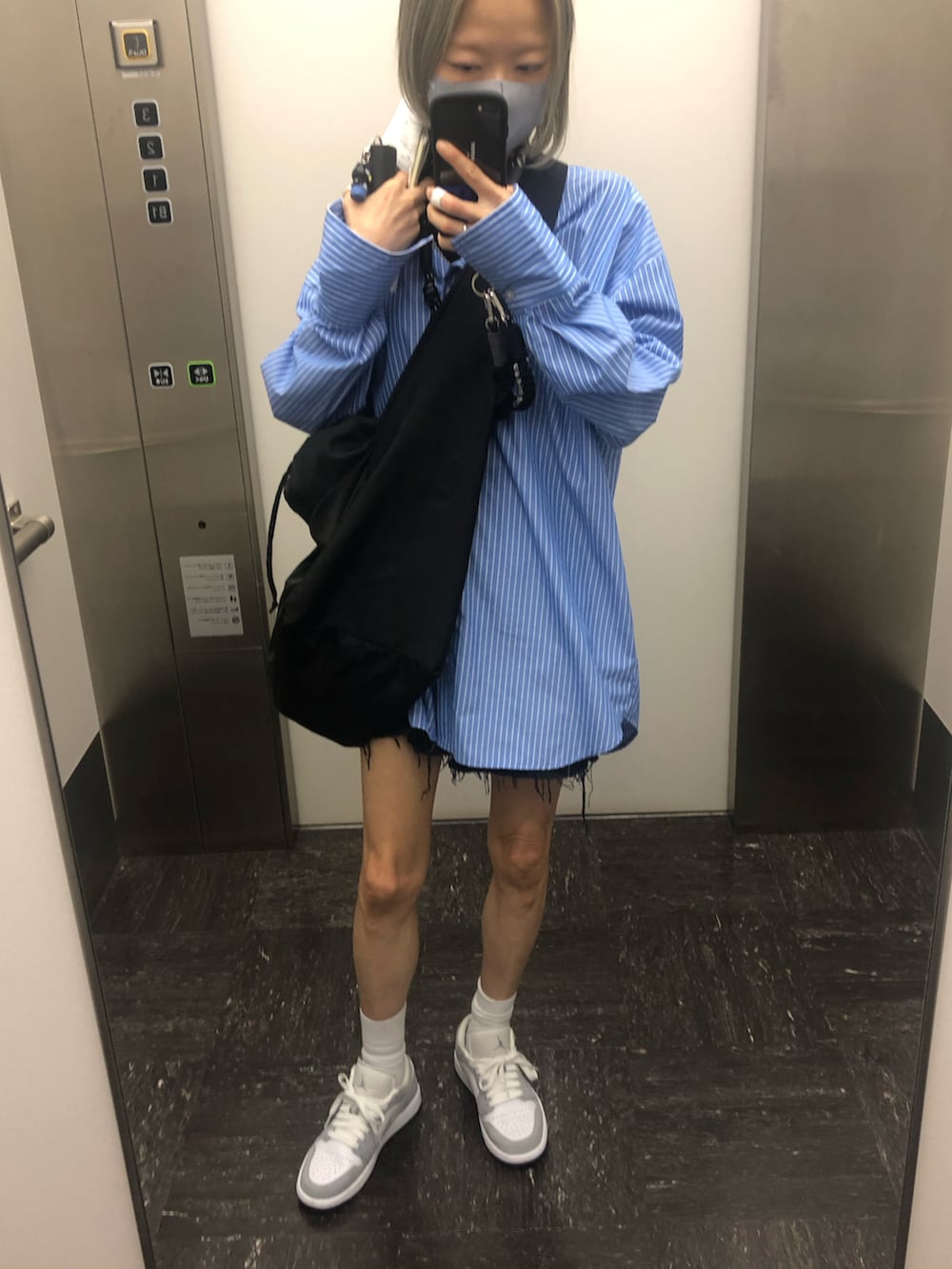 グレー系のスニーカー、ブラック系のショルダーバッグ、ブルー系のシャツ/ブラウスを着用したレディースの夏コーディネートの2枚目の写真