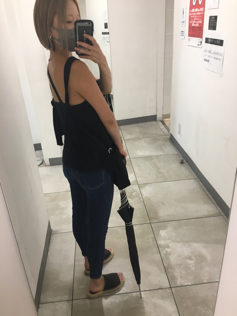 ブラック系のタンクトップ、ブラック系のショルダーバッグ、グレー系のトートバッグを着用したレディースの秋コーディネートの3枚目の写真