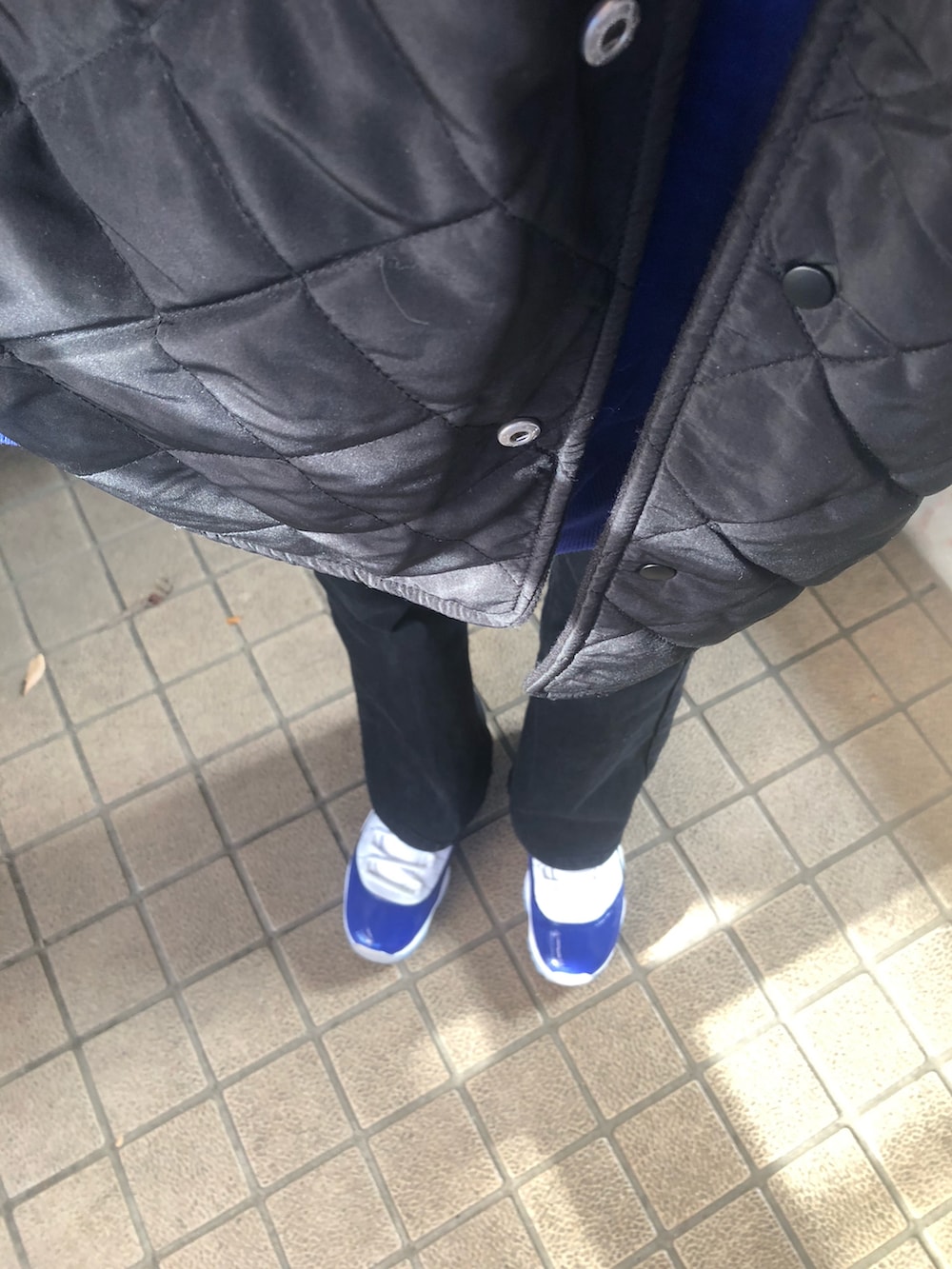 ブラック系のデニムパンツ、ブラック系のブルゾン、レッド系のショルダーバッグを着用したレディースの冬コーディネートの5枚目の写真