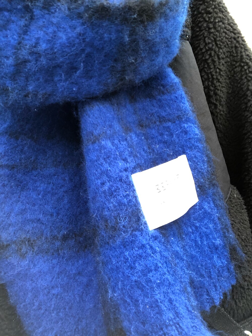 ブラック系のTシャツ/カットソー、ブルー系のマフラー、その他のネックレスを着用したレディースの冬コーディネートの3枚目の写真