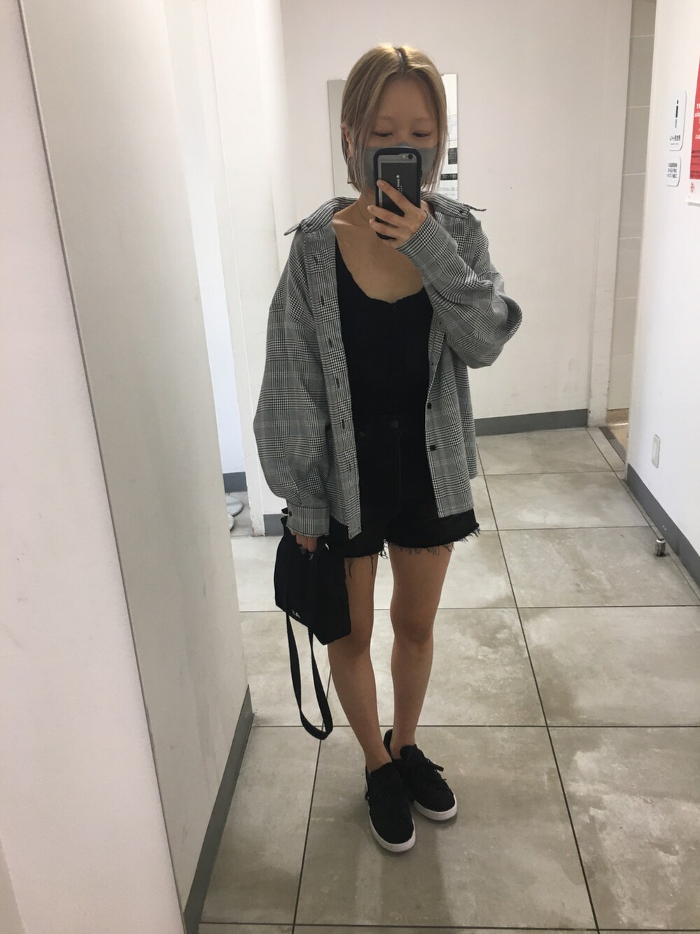 ブラック系のスニーカー、ブラック系のタンクトップ、ブラック系のショルダーバッグを着用したレディースの秋コーディネートの3枚目の写真