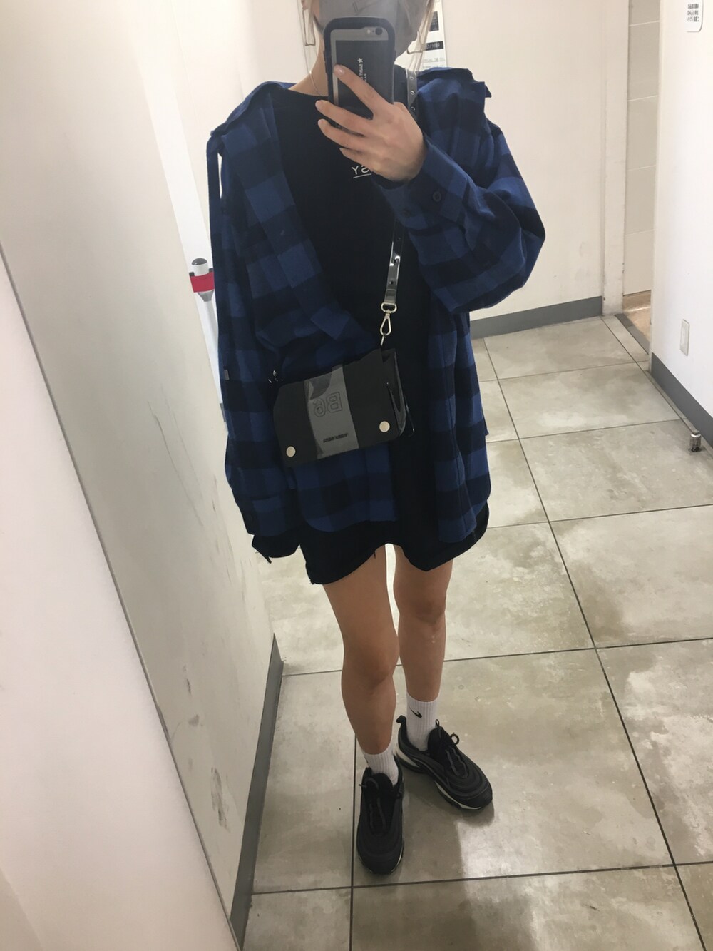 ブラック系のスニーカー、ブルー系のその他アウター、ブラック系のショルダーバッグを着用したレディースの秋コーディネートの2枚目の写真