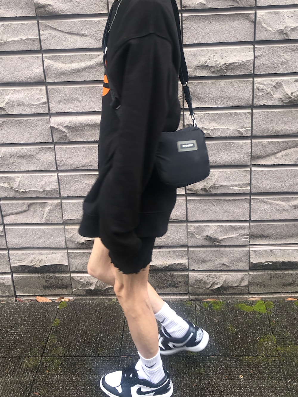 ホワイト系のスニーカー、ブラック系のショルダーバッグ、ブラック系のその他パンツを着用したレディースの秋コーディネートの4枚目の写真