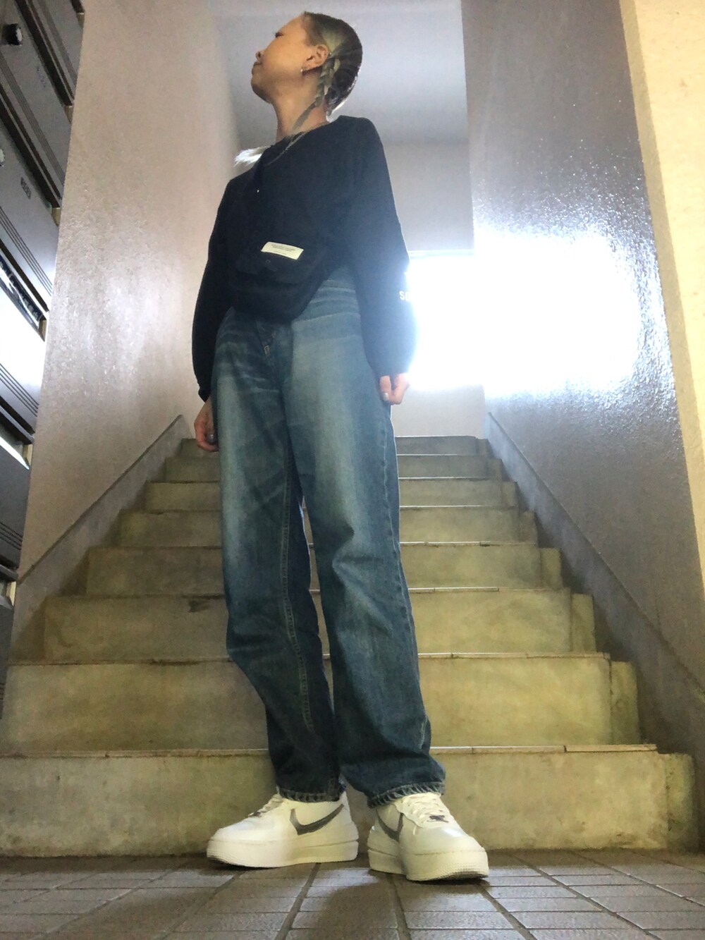 ブルー系のデニムパンツ、ホワイト系のスニーカー、ブルー系のシャツ/ブラウスを着用したレディースの秋コーディネートの3枚目の写真