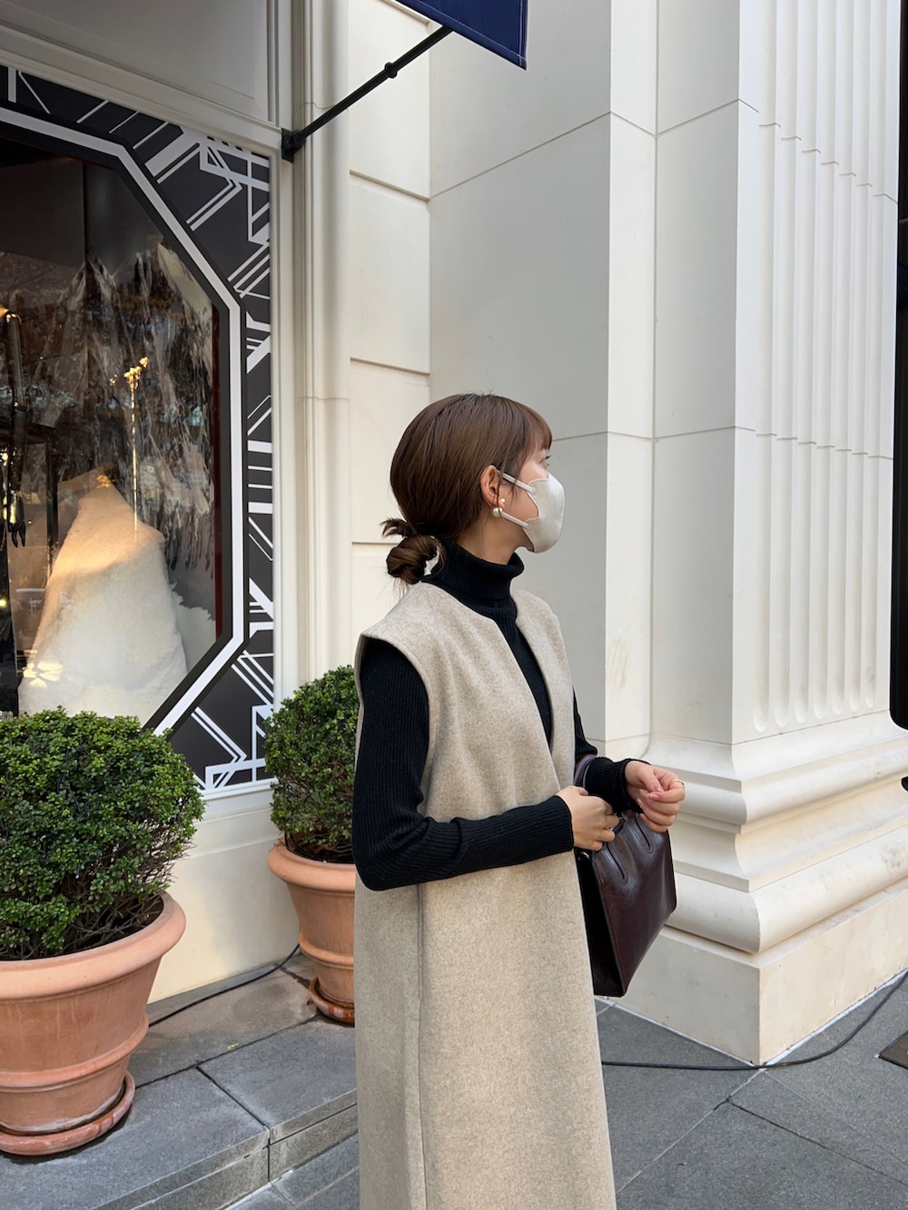 ブラウン系のバッグ、ベージュ系のワンピースを着用したレディースの冬コーディネートの2枚目の写真