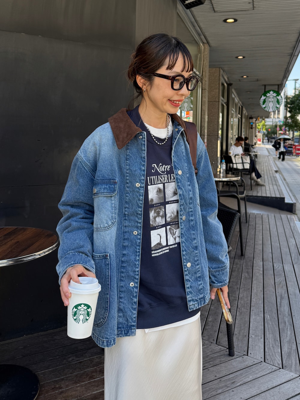 ホワイト系のスカート、ブルー系のブルゾン、ブラック系のその他シューズを着用したレディースの秋コーディネートの3枚目の写真