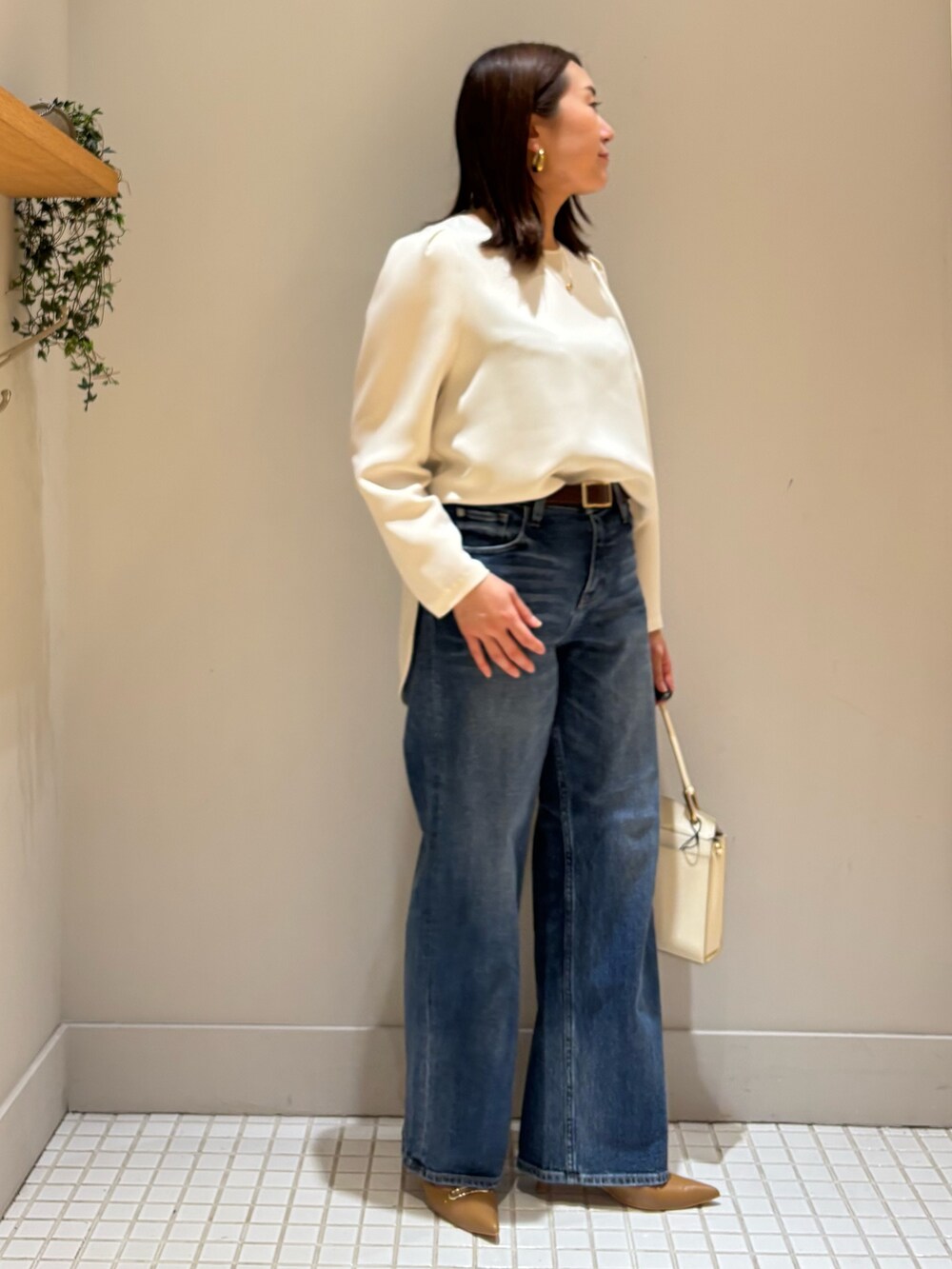 ブルー系のデニムパンツ、ブラック系のテーラードジャケット、ホワイト系のシャツ/ブラウスを着用したレディースの冬コーディネートの2枚目の写真