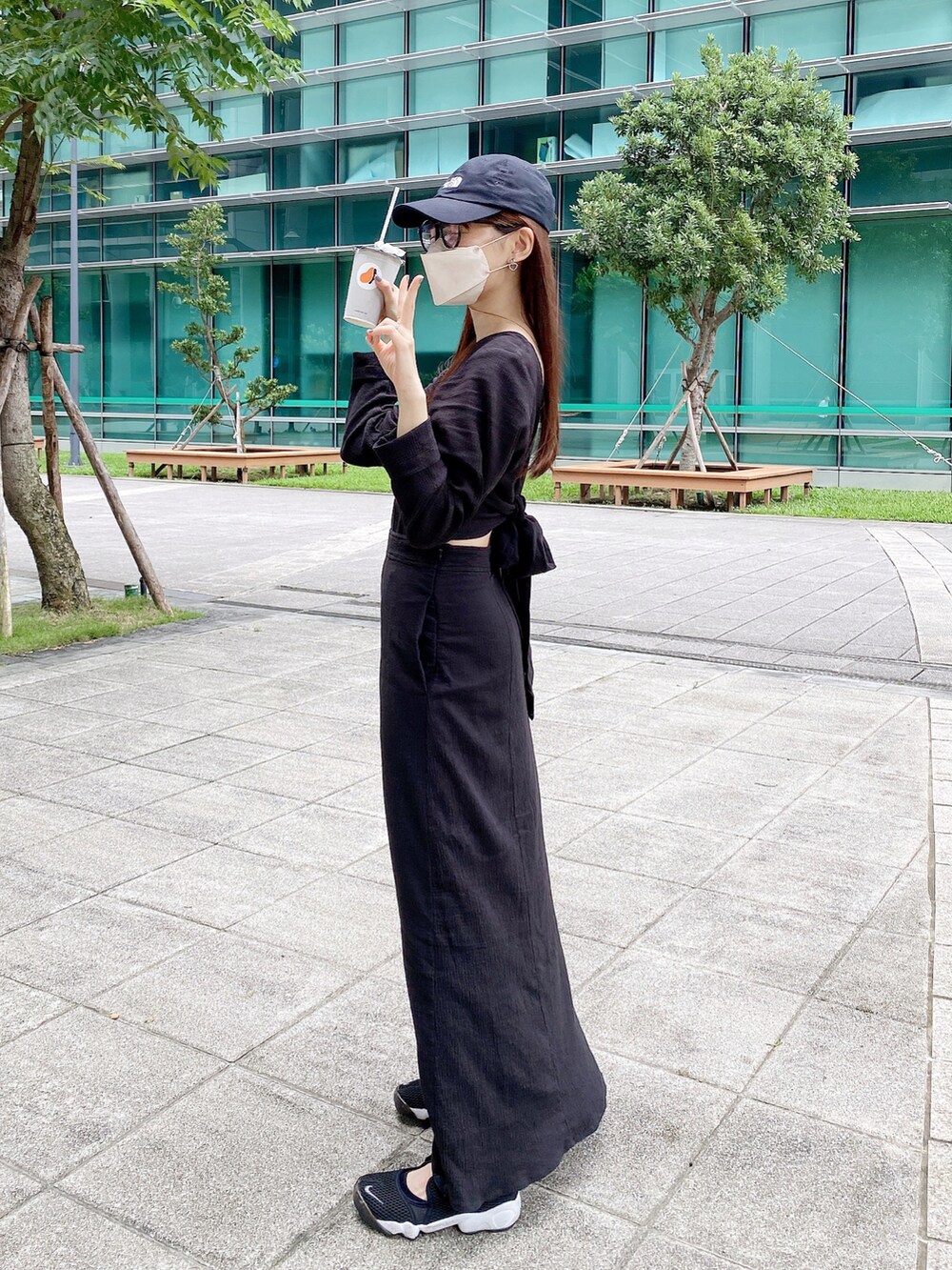 ブラック系のワンピース、ブラック系のスニーカーを着用したレディースの夏コーディネートの3枚目の写真