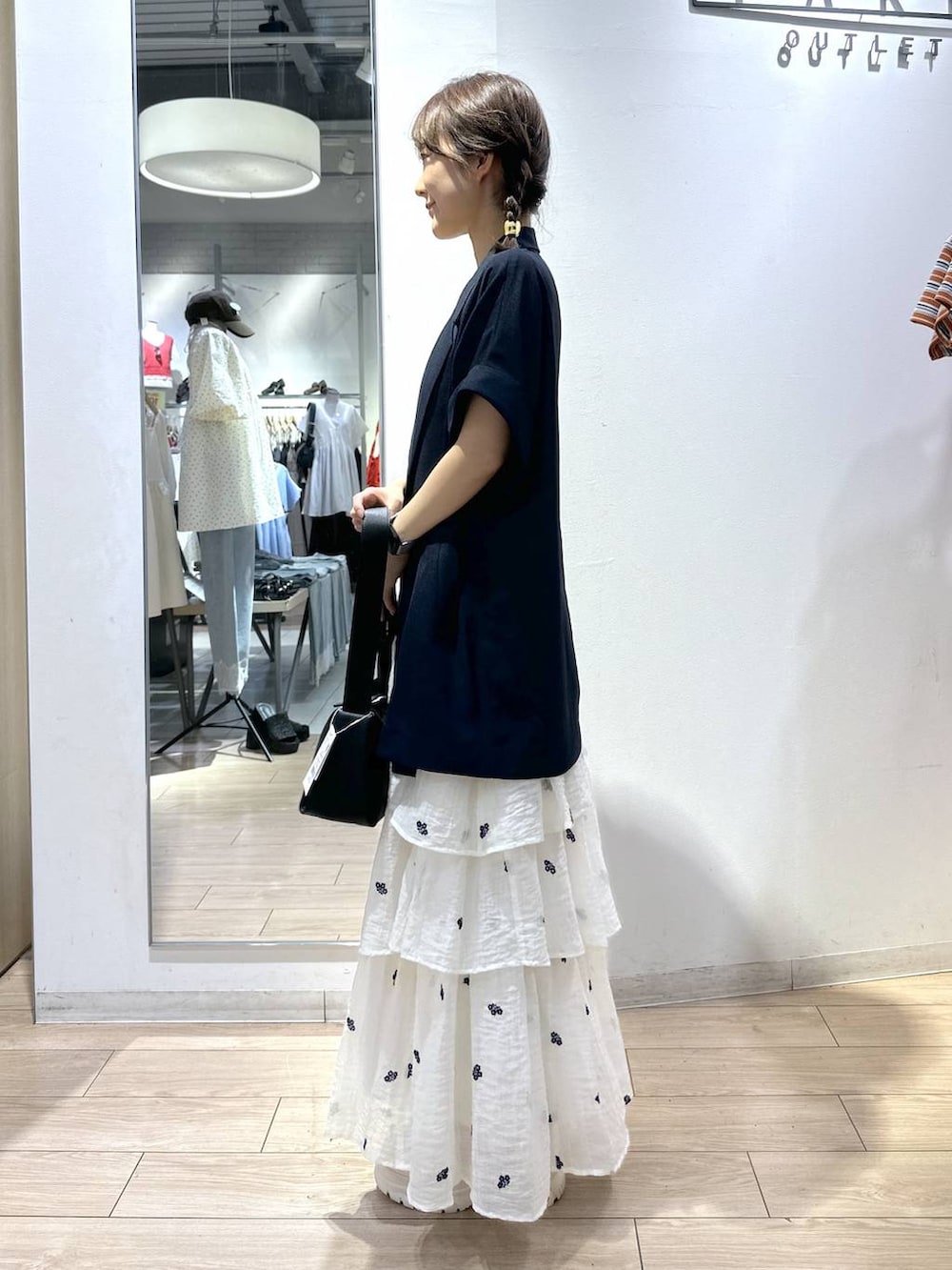 ホワイト系のTシャツ/カットソー、ブルー系のテーラードジャケット、ホワイト系のスカートを着用したレディースの夏コーディネートの2枚目の写真
