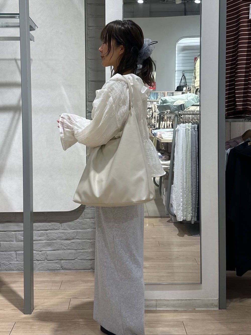 ベージュ系のTシャツ/カットソー、グレー系のスカート、ホワイト系のショルダーバッグを着用したレディースの春コーディネートの3枚目の写真