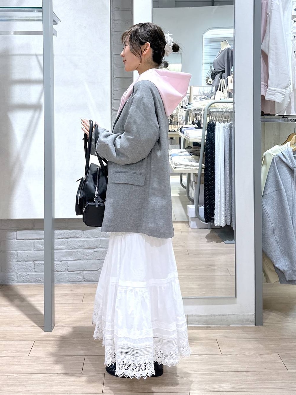 ホワイト系のTシャツ/カットソー、ピンク系のパーカー、グレー系のテーラードジャケットを着用したレディースの春コーディネートの3枚目の写真