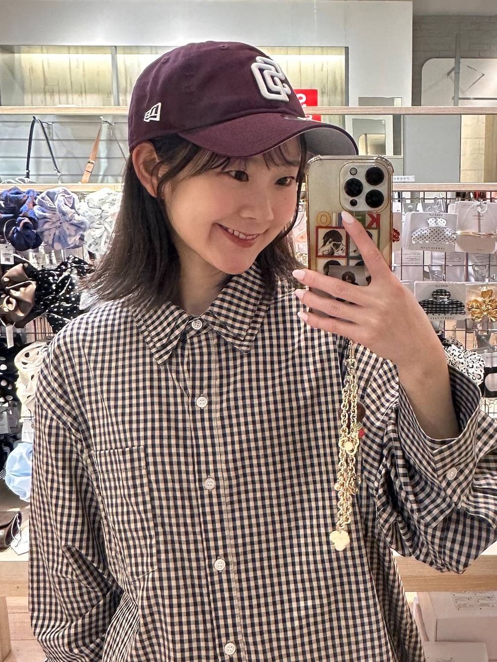 ブラウン系のシャツ/ブラウス、レッド系のキャップを着用したレディースの春コーディネートの2枚目の写真