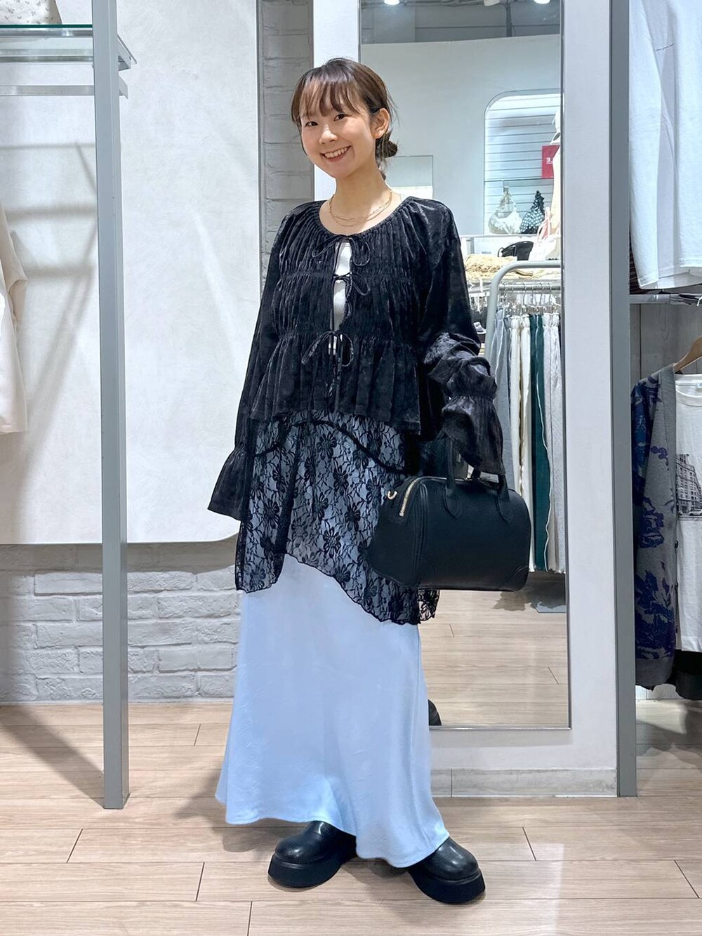 ブルー系のスカート、ブラック系のスカート、ブラック系のショルダーバッグを着用したレディースの夏コーディネートの2枚目の写真