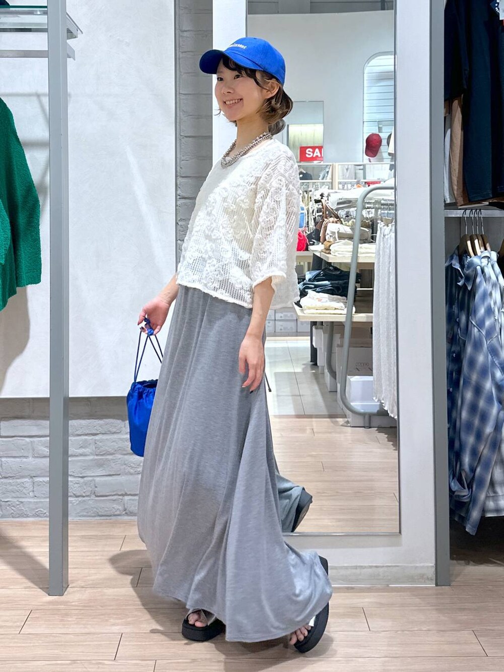 シルバー系のサンダル、ホワイト系のTシャツ/カットソー、ブルー系のショルダーバッグを着用したレディースの夏コーディネートの3枚目の写真