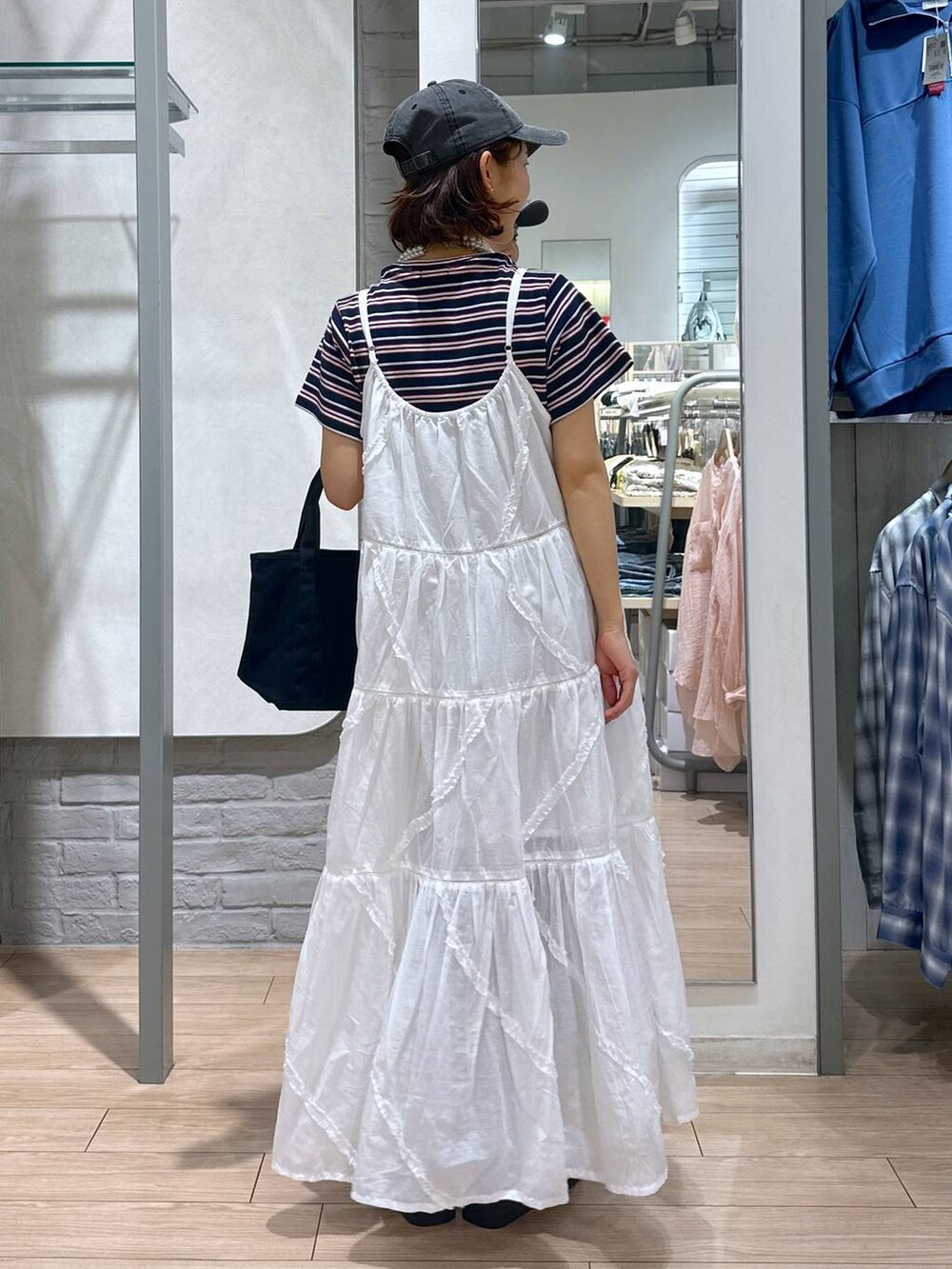 ブルー系のTシャツ/カットソー、ブラック系のデニムパンツ、ブラック系のショルダーバッグを着用したレディースの春コーディネートの3枚目の写真