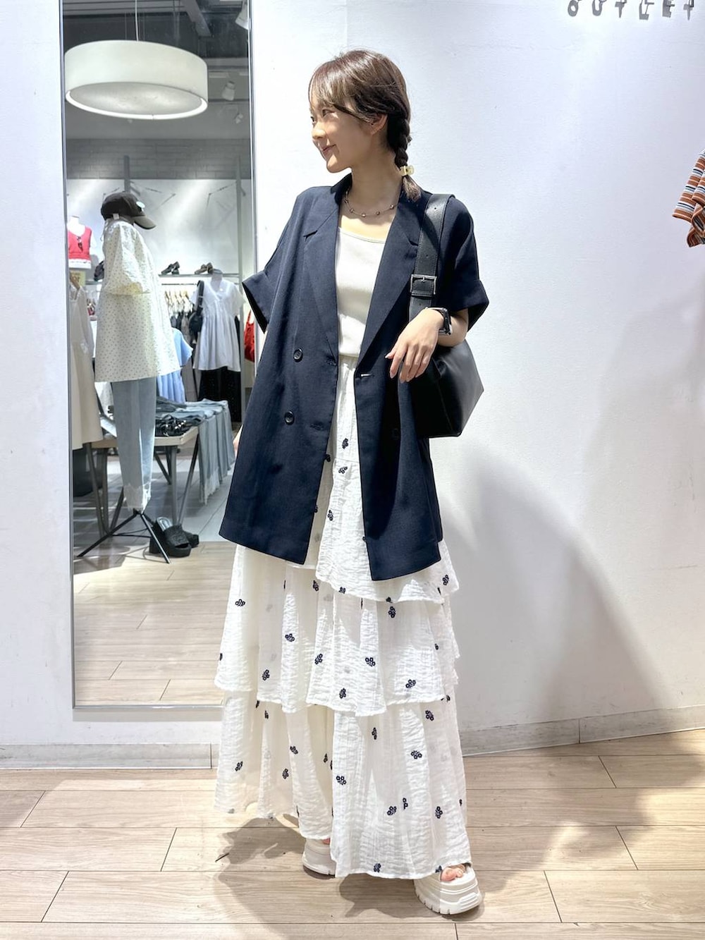 ホワイト系のTシャツ/カットソー、ブルー系のテーラードジャケット、ホワイト系のスカートを着用したレディースの夏コーディネートの5枚目の写真