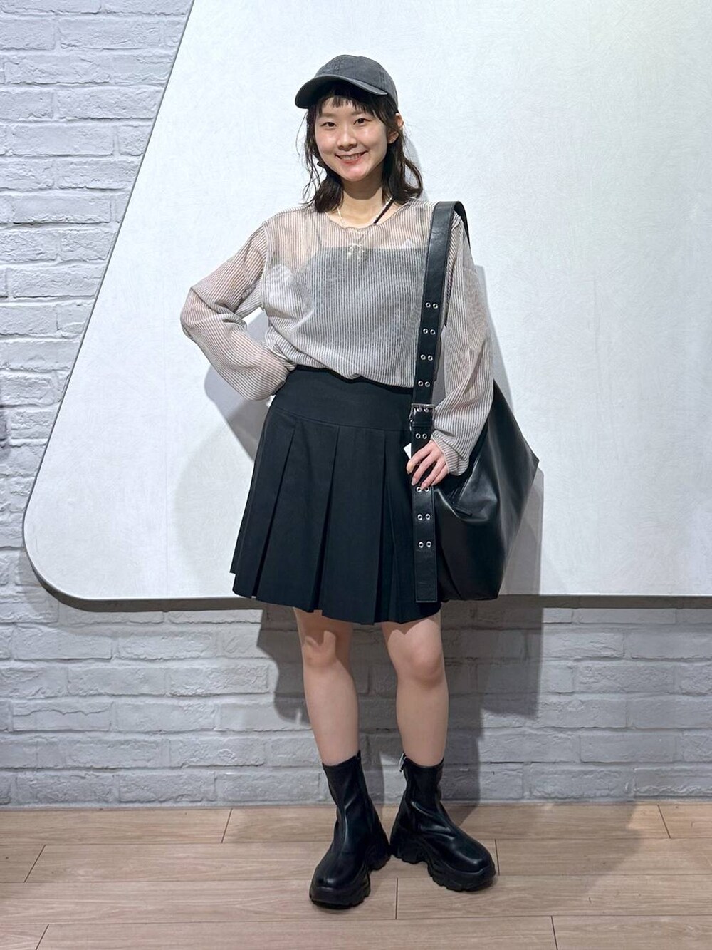 ブラック系のスカート、ブラック系のボディバッグ/ウエストポーチ、ホワイト系のシャツ/ブラウスを着用したレディースの夏コーディネートの5枚目の写真