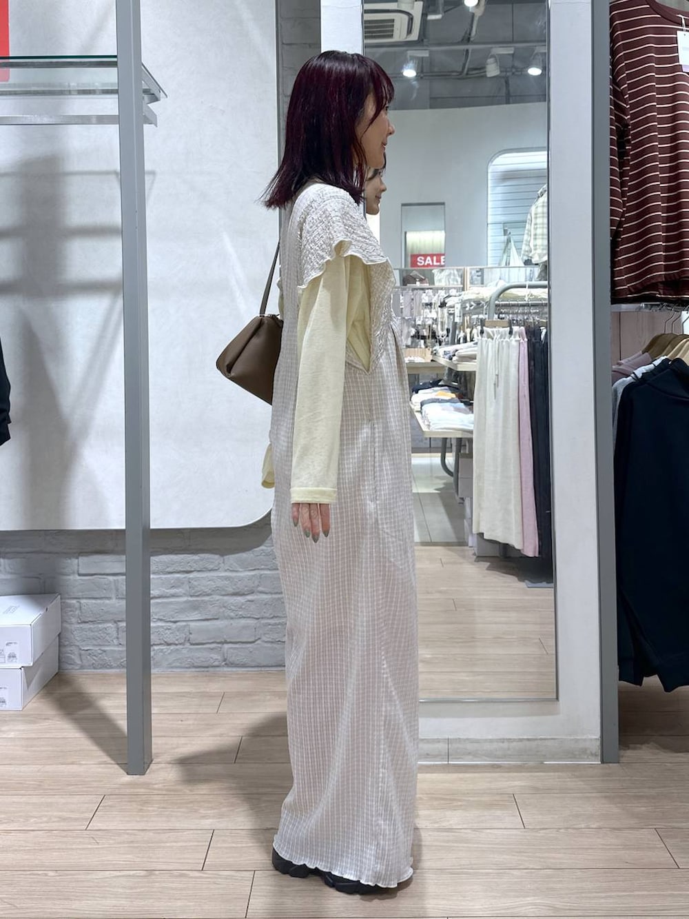 ベージュ系のサロペット/オーバーオール、イエロー系のTシャツ/カットソー、ブラウン系のローファーを着用したレディースの春コーディネートの4枚目の写真