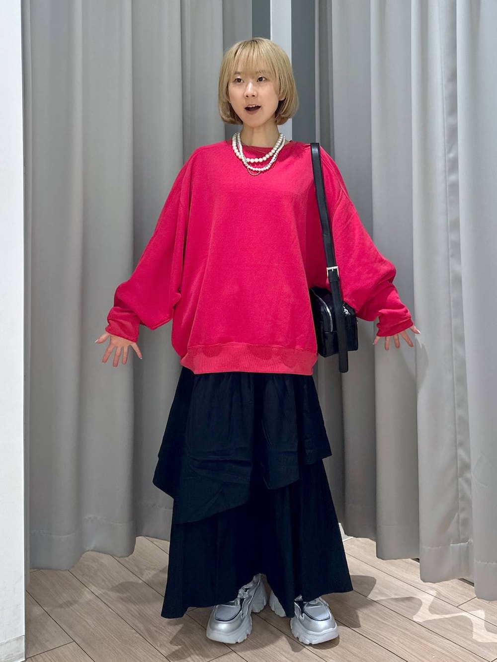 ブラック系のショルダーバッグ、レッド系のスウェット、シルバー系のスニーカーを着用したレディースの秋コーディネートの5枚目の写真