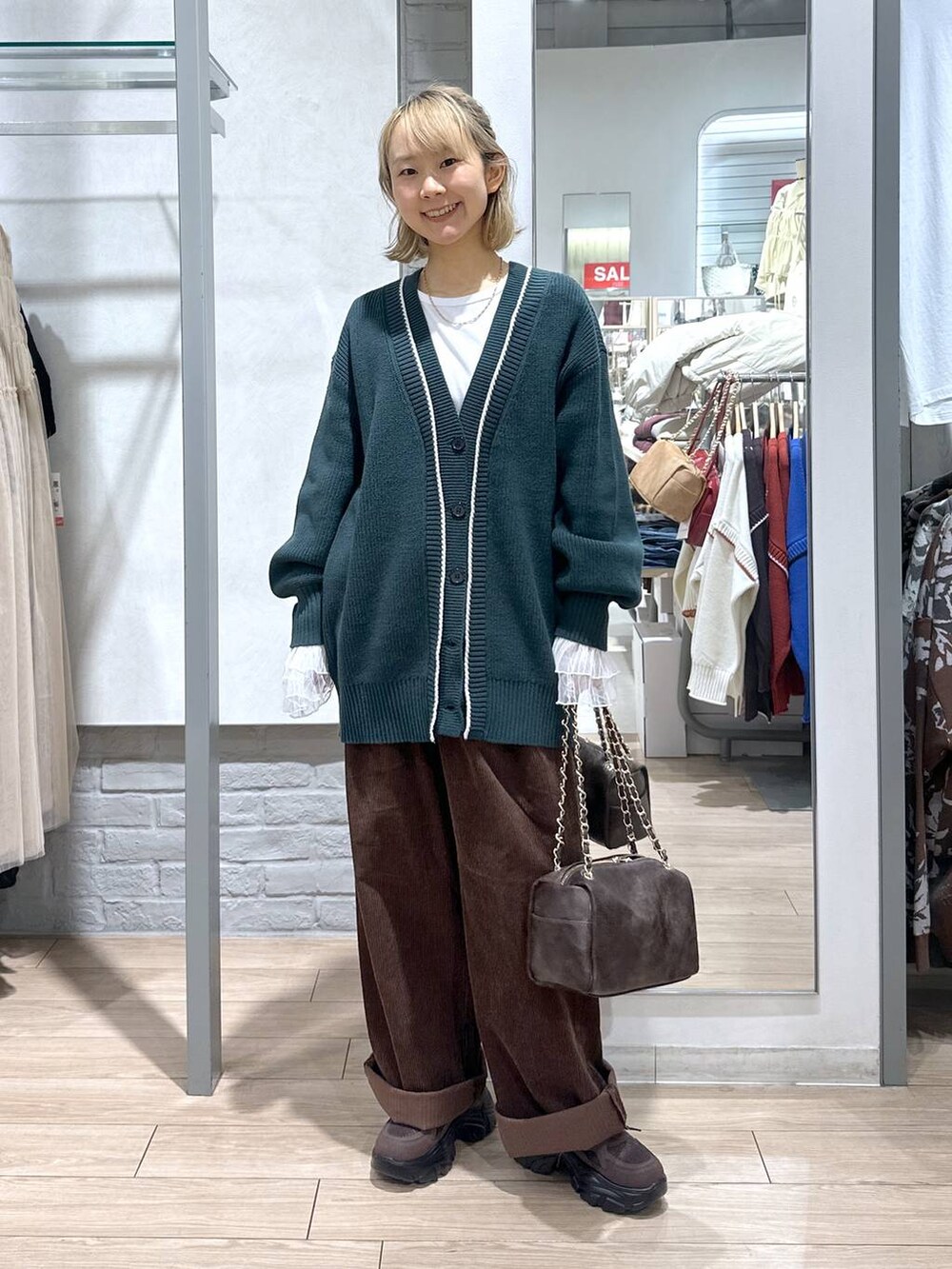 グリーン系のカーディガン/ボレロ、ブラウン系のその他パンツ、ホワイト系のTシャツ/カットソーを着用したレディースの秋コーディネートの2枚目の写真