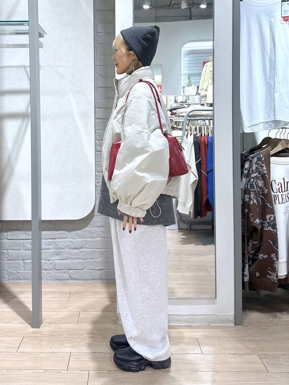 ホワイト系のその他アウター、ブラック系のブーツ、グレー系のスウェットパンツを着用したレディースの秋コーディネートの3枚目の写真