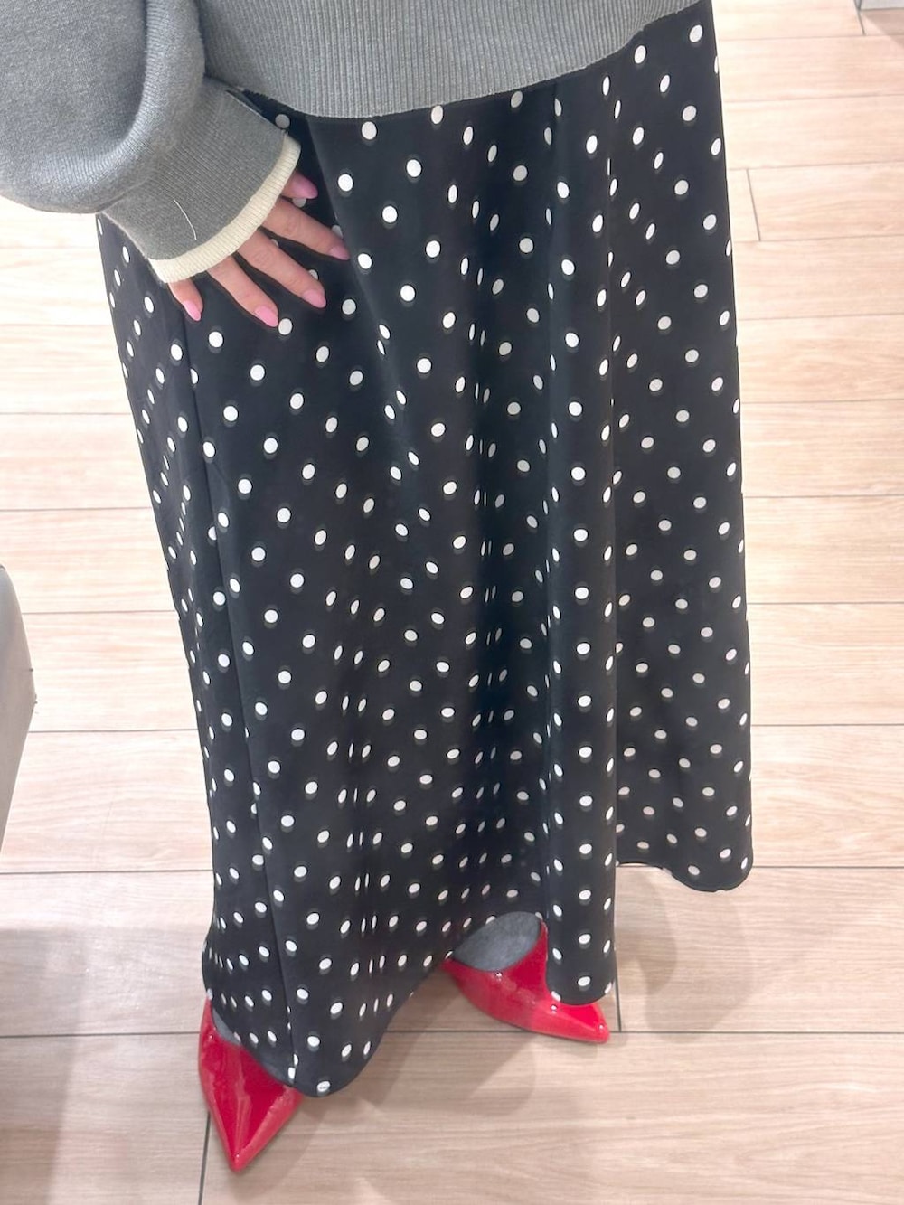 ブラック系のスカート、レッド系のパンプス、グレー系のニット/セーターを着用したレディースの冬コーディネートの4枚目の写真