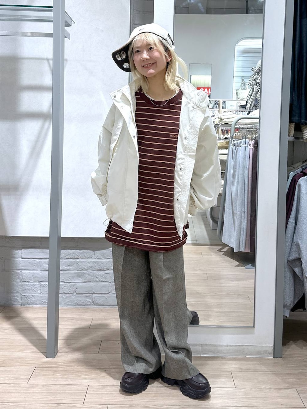 ホワイト系のナイロンジャケット、ブラウン系のデニムパンツ、ブラウン系のローファーを着用したレディースの冬コーディネートの2枚目の写真