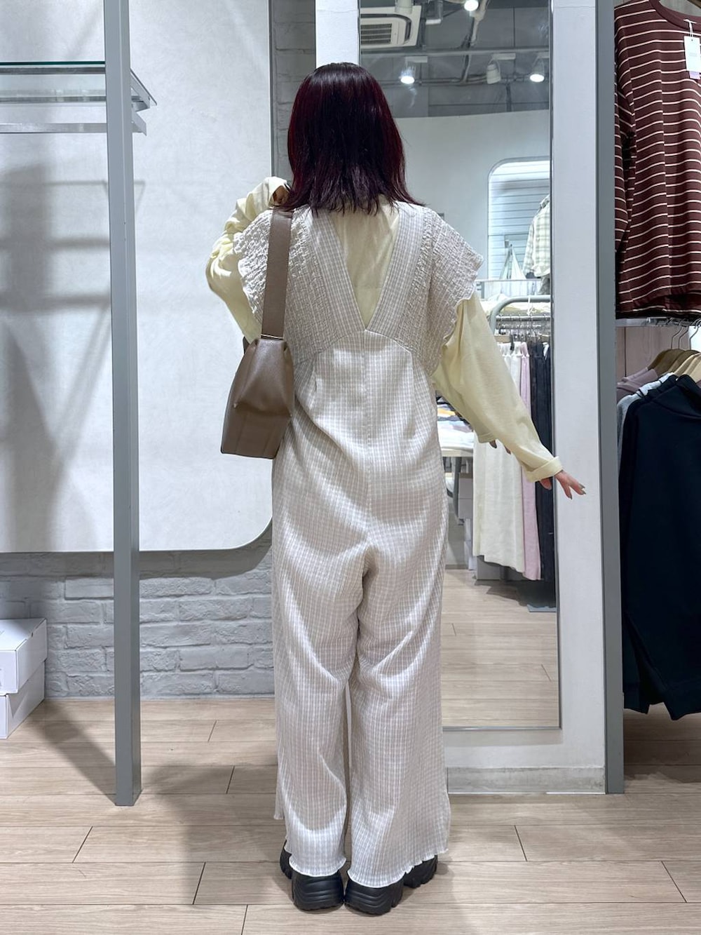 ベージュ系のサロペット/オーバーオール、イエロー系のTシャツ/カットソー、ブラウン系のローファーを着用したレディースの春コーディネートの3枚目の写真