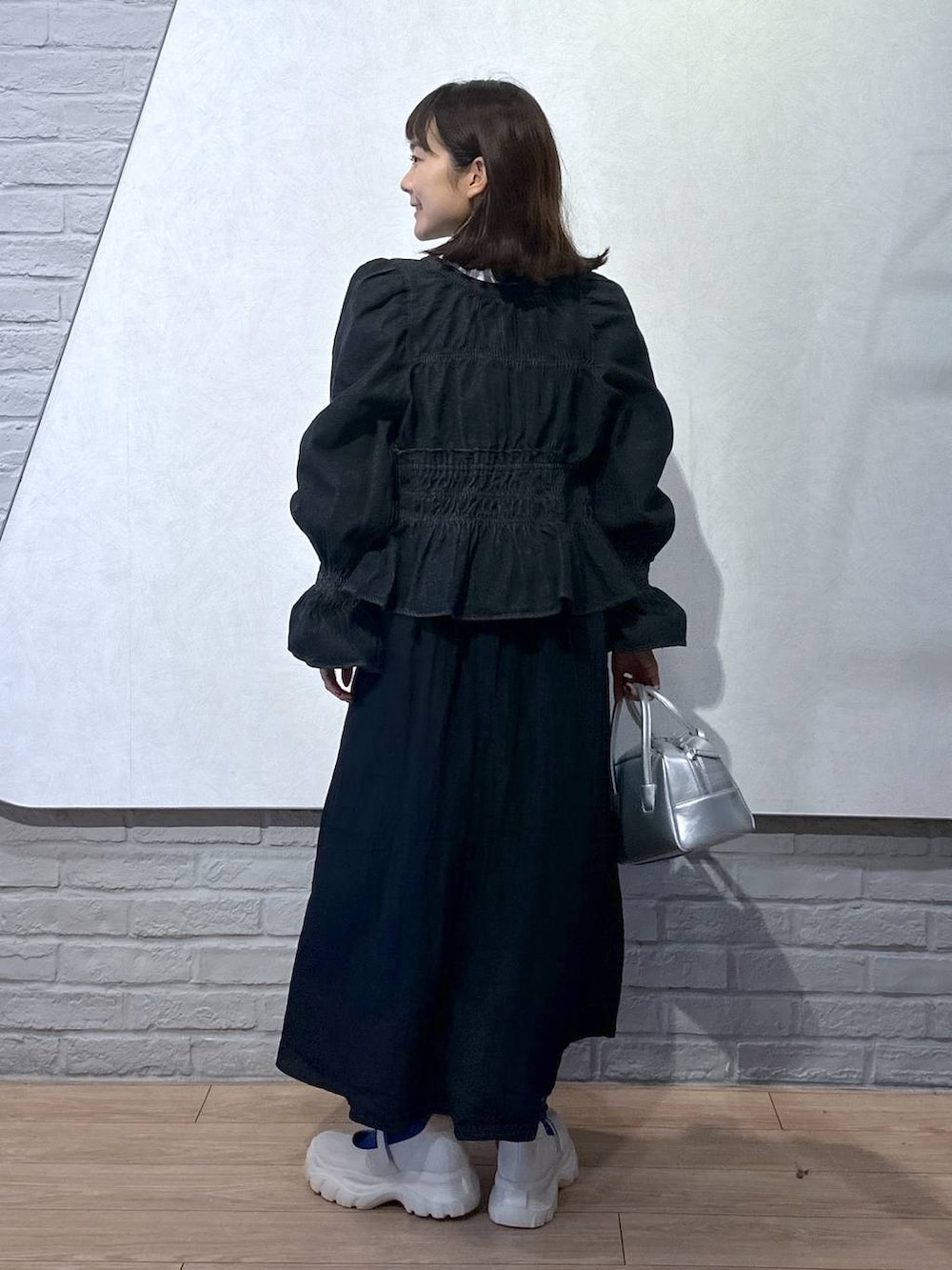 ブラック系のシャツ/ブラウス、ホワイト系のTシャツ/カットソー、ホワイト系のスニーカーを着用したレディースの秋コーディネートの3枚目の写真