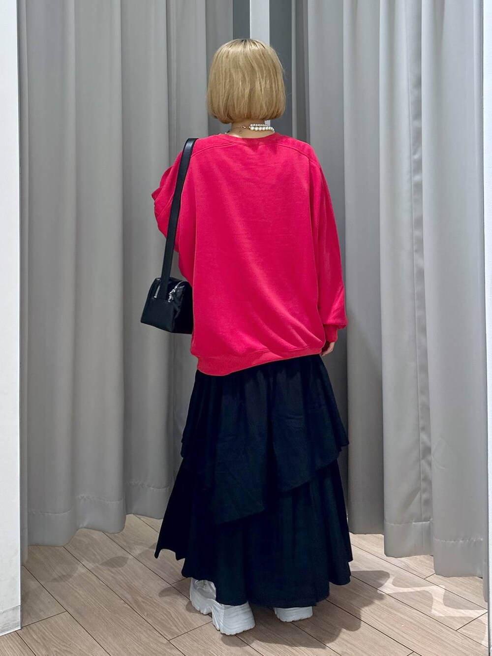 ブラック系のショルダーバッグ、レッド系のスウェット、シルバー系のスニーカーを着用したレディースの秋コーディネートの4枚目の写真