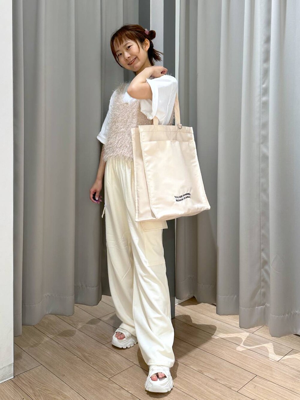 ホワイト系のサンダル、ホワイト系のトートバッグ、ホワイト系のキャミソールを着用したレディースの夏コーディネートの4枚目の写真