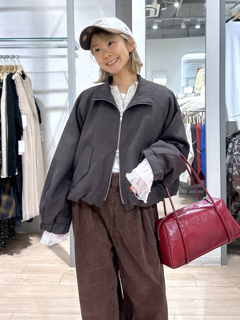 ブラウン系のブルゾン、ブラウン系のその他パンツ、ホワイト系のTシャツ/カットソーを着用したレディースの秋コーディネートの4枚目の写真