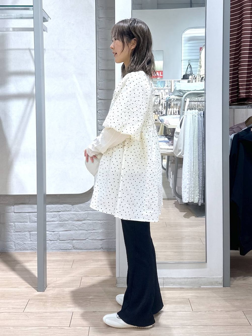 ベージュ系のTシャツ/カットソー、ホワイト系のスニーカー、ブラック系のその他パンツを着用したレディースの春コーディネートの3枚目の写真