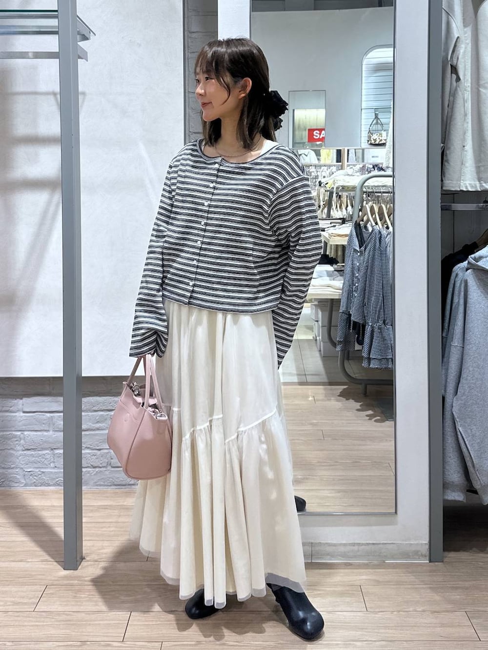 ピンク系のショルダーバッグ、ブラック系のサンダル、ホワイト系のニット/セーターを着用したレディースの春コーディネートの4枚目の写真