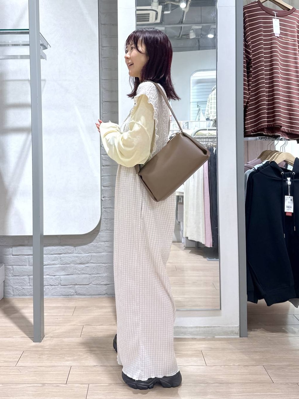 ベージュ系のサロペット/オーバーオール、イエロー系のTシャツ/カットソー、ブラウン系のローファーを着用したレディースの春コーディネートの2枚目の写真