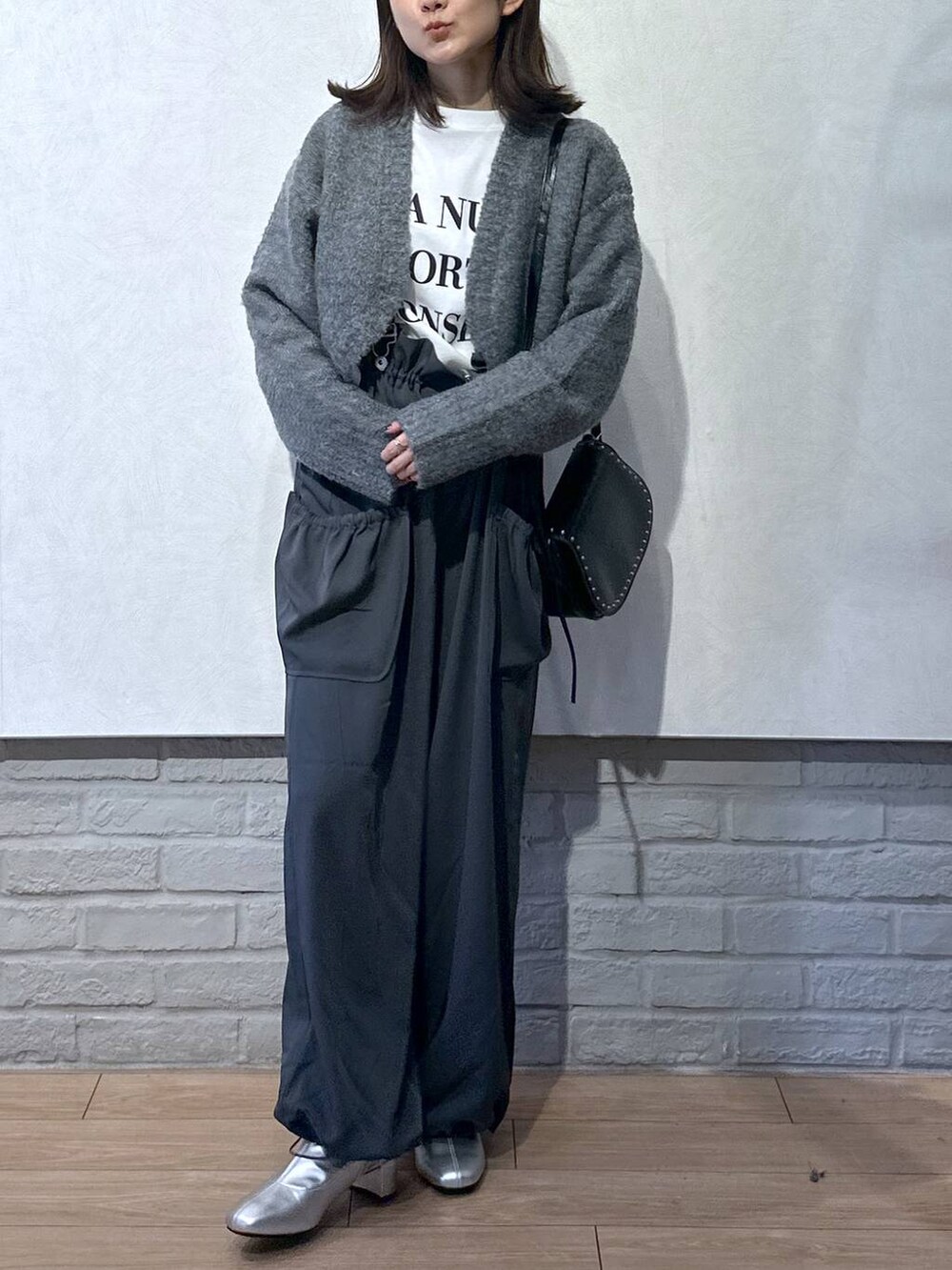 グレー系のワンピース、ブラック系のショルダーバッグ、ホワイト系のTシャツ/カットソーを着用したレディースの秋コーディネートの3枚目の写真