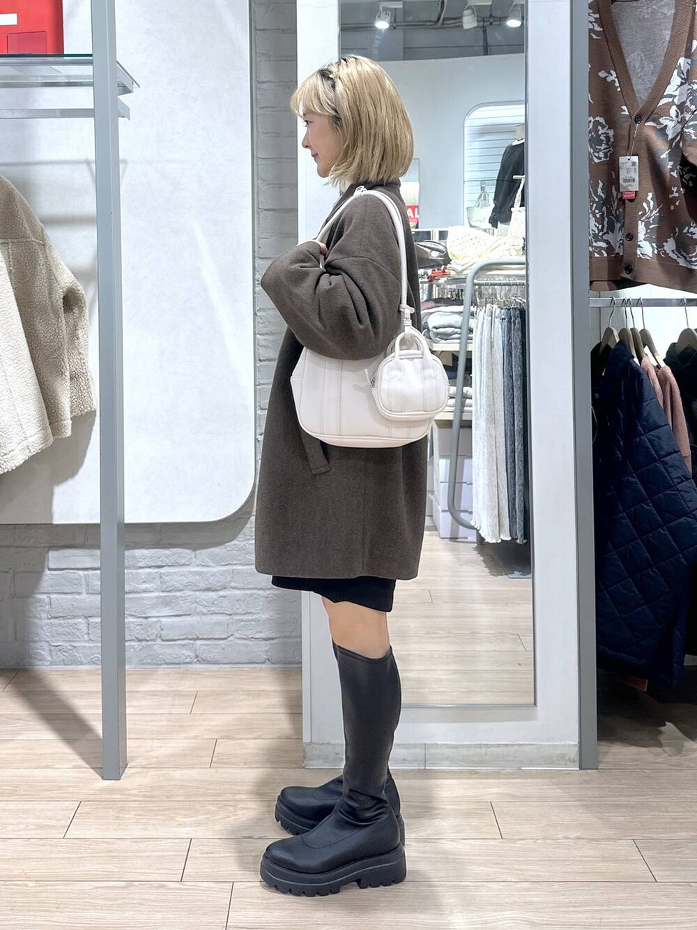 ブラウン系のその他アウター、ブラック系のその他パンツ、ブラック系のブーツを着用したレディースの冬コーディネートの3枚目の写真