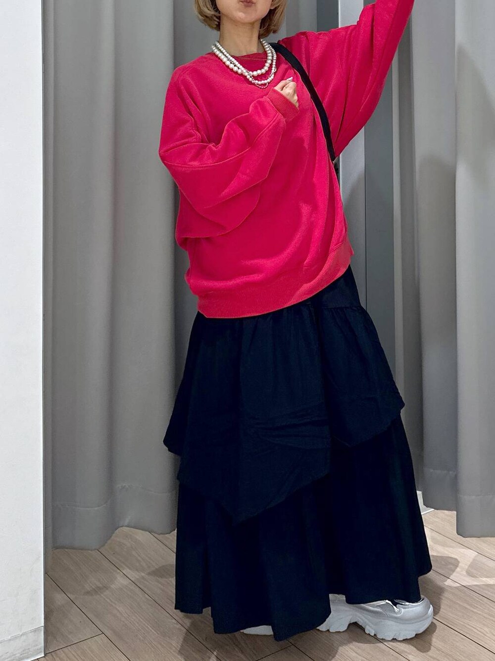 ブラック系のショルダーバッグ、レッド系のスウェット、シルバー系のスニーカーを着用したレディースの秋コーディネートの3枚目の写真