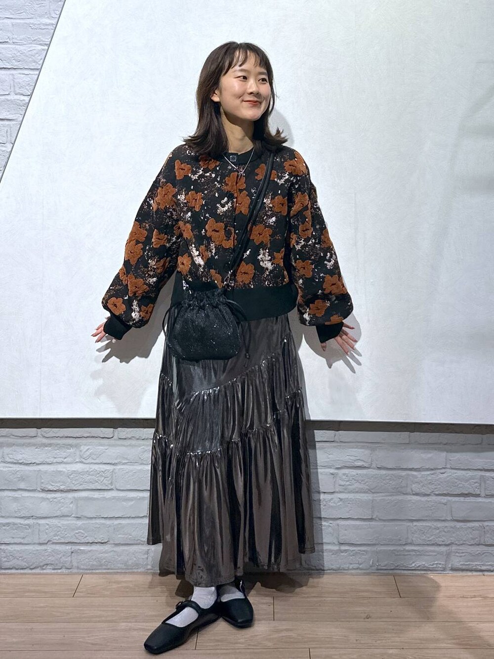 ブラック系のショルダーバッグ、グレー系のスカート、ブラック系のバレエシューズを着用したレディースの秋コーディネートの3枚目の写真