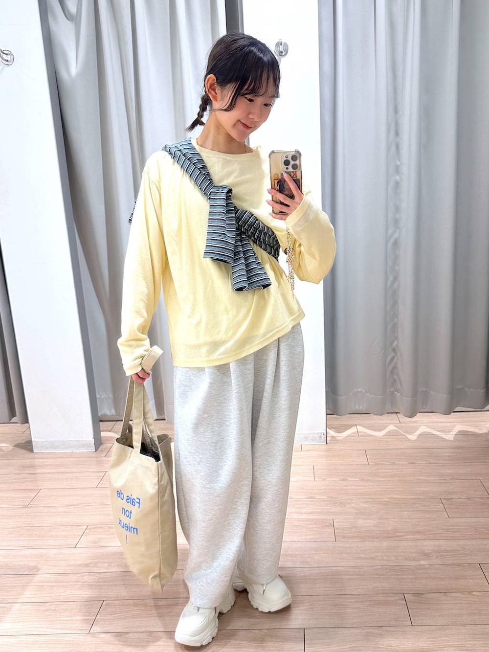 グレー系のスウェットパンツ、イエロー系のTシャツ/カットソー、ベージュ系のトートバッグを着用したレディースの春コーディネートの5枚目の写真
