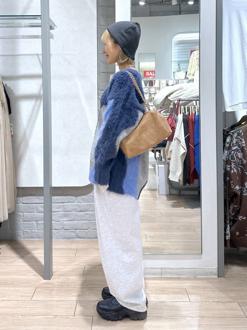 ブラック系のブーツ、ブルー系のカーディガン/ボレロ、グレー系のスウェットパンツを着用したレディースの秋コーディネートの2枚目の写真