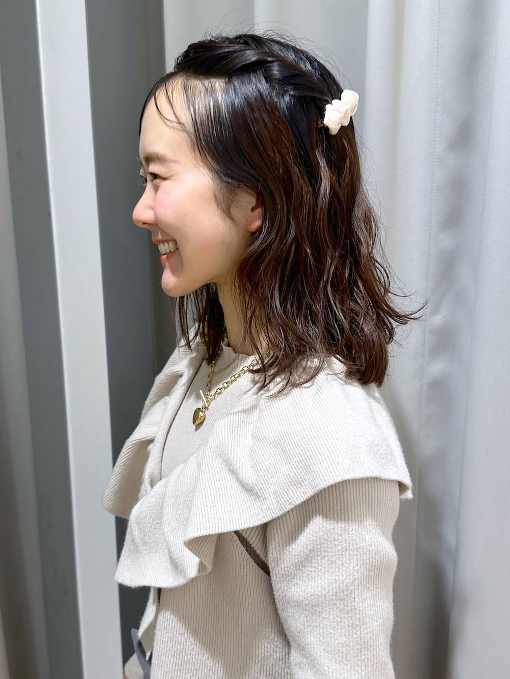 ベージュ系のニット/セーター、ブラウン系のネックレス、ホワイト系のバレッタ/ヘアクリップを着用したレディースの冬コーディネートの2枚目の写真