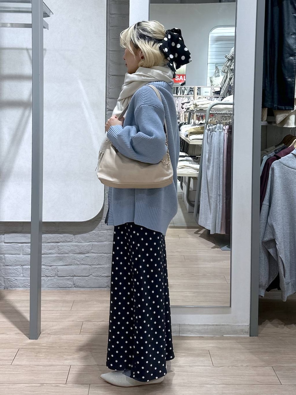 ブラック系のスカート、ブルー系のカーディガン/ボレロ、ホワイト系のパンプスを着用したレディースの冬コーディネートの3枚目の写真