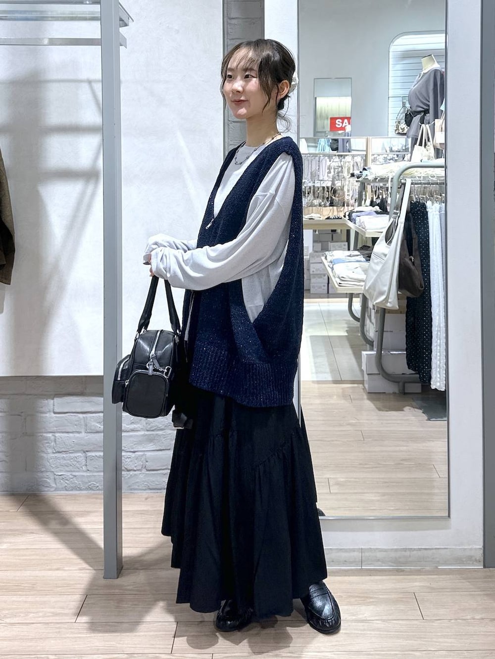 グレー系のTシャツ/カットソー、ブラック系のボストンバッグ、ブラック系のローファーを着用したレディースの春コーディネートの2枚目の写真