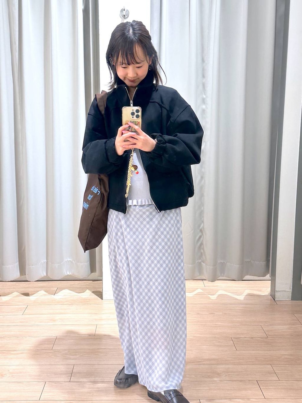 ブラウン系のトートバッグ、ブラウン系のローファー、ブルー系のスカートを着用したレディースの春コーディネートの5枚目の写真