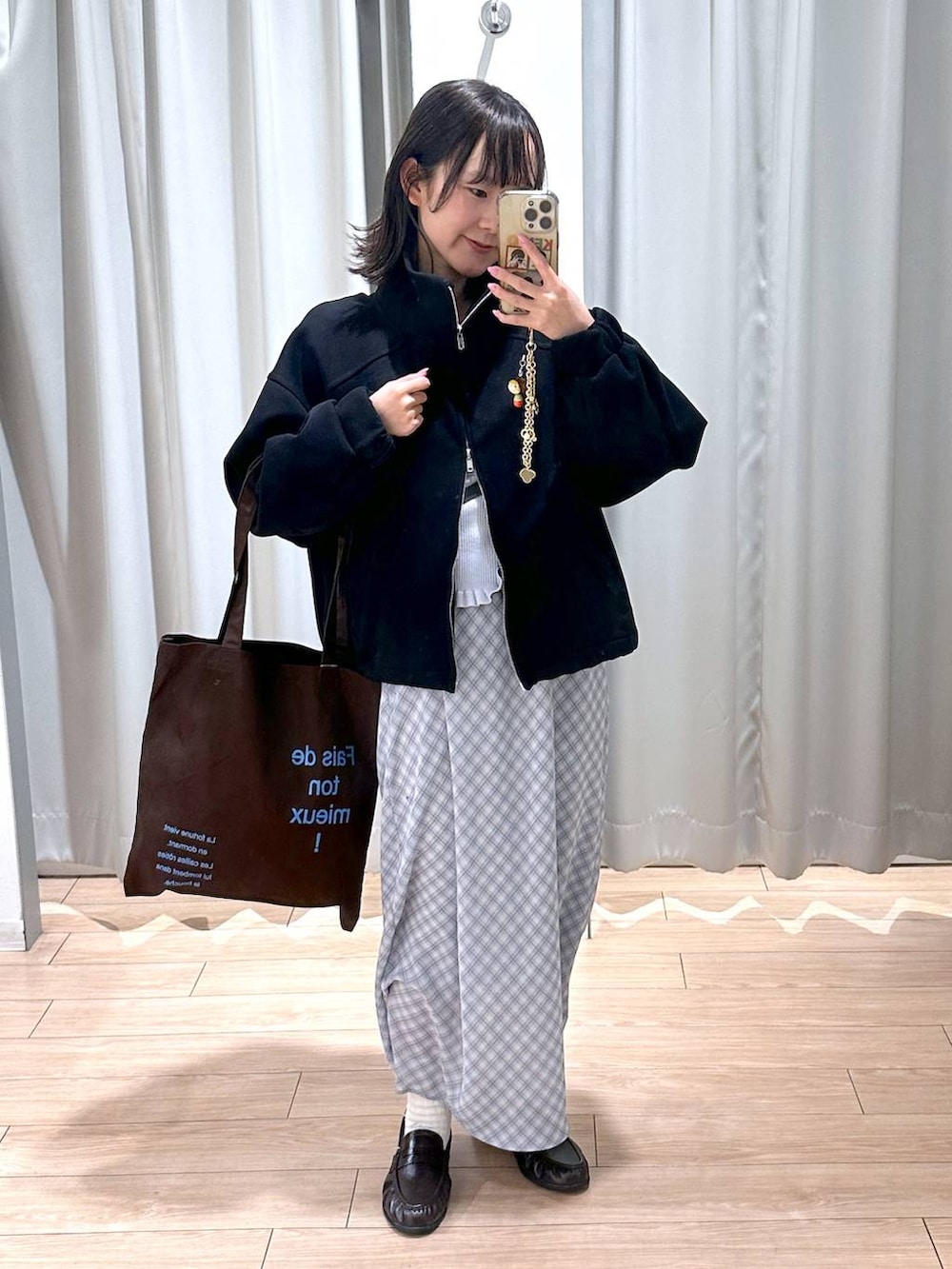 ブラウン系のトートバッグ、ブラウン系のローファー、ブルー系のスカートを着用したレディースの春コーディネートの4枚目の写真